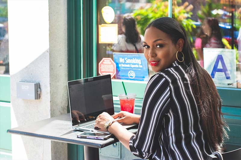 Kobieta w kawiarni korzysta z laptopa